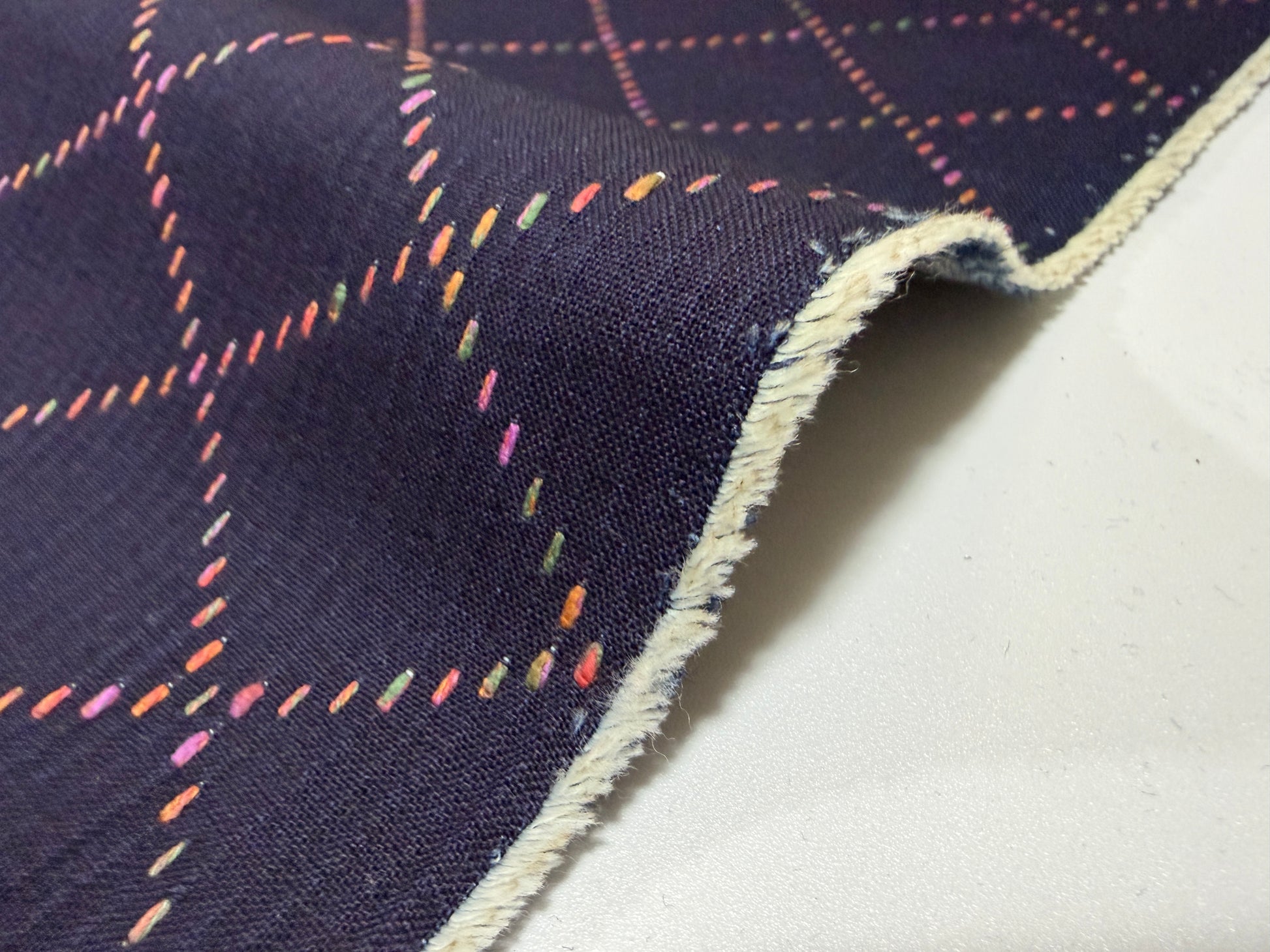 Okayama Denim 7 oz Sashiko fabric showing colorful stitching on a navy background, perfect for sewing projects.