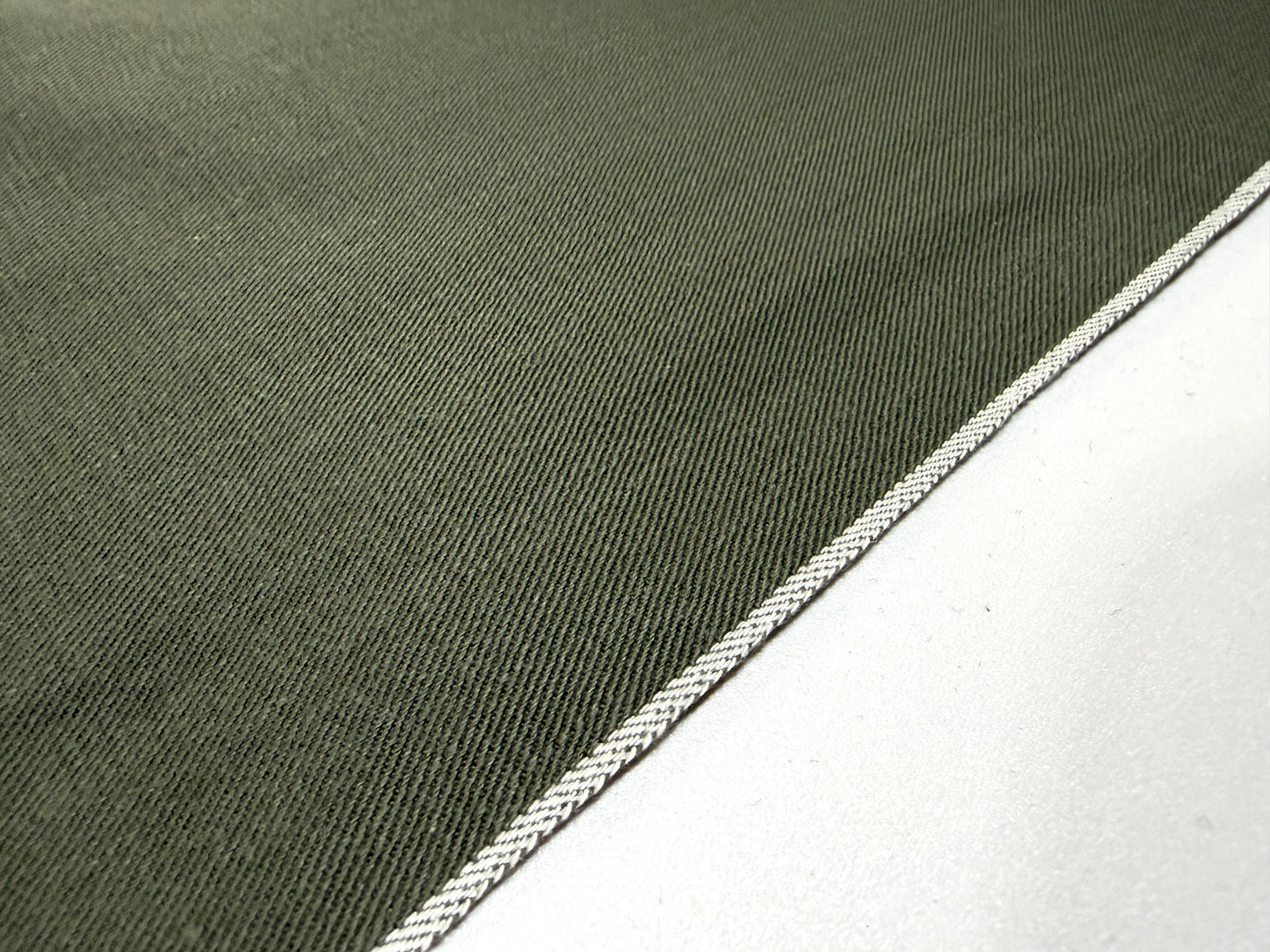 Okayama Denim 7.5 oz Japanese cotton olive dungaree fabric showing traditional selvage edge detail.