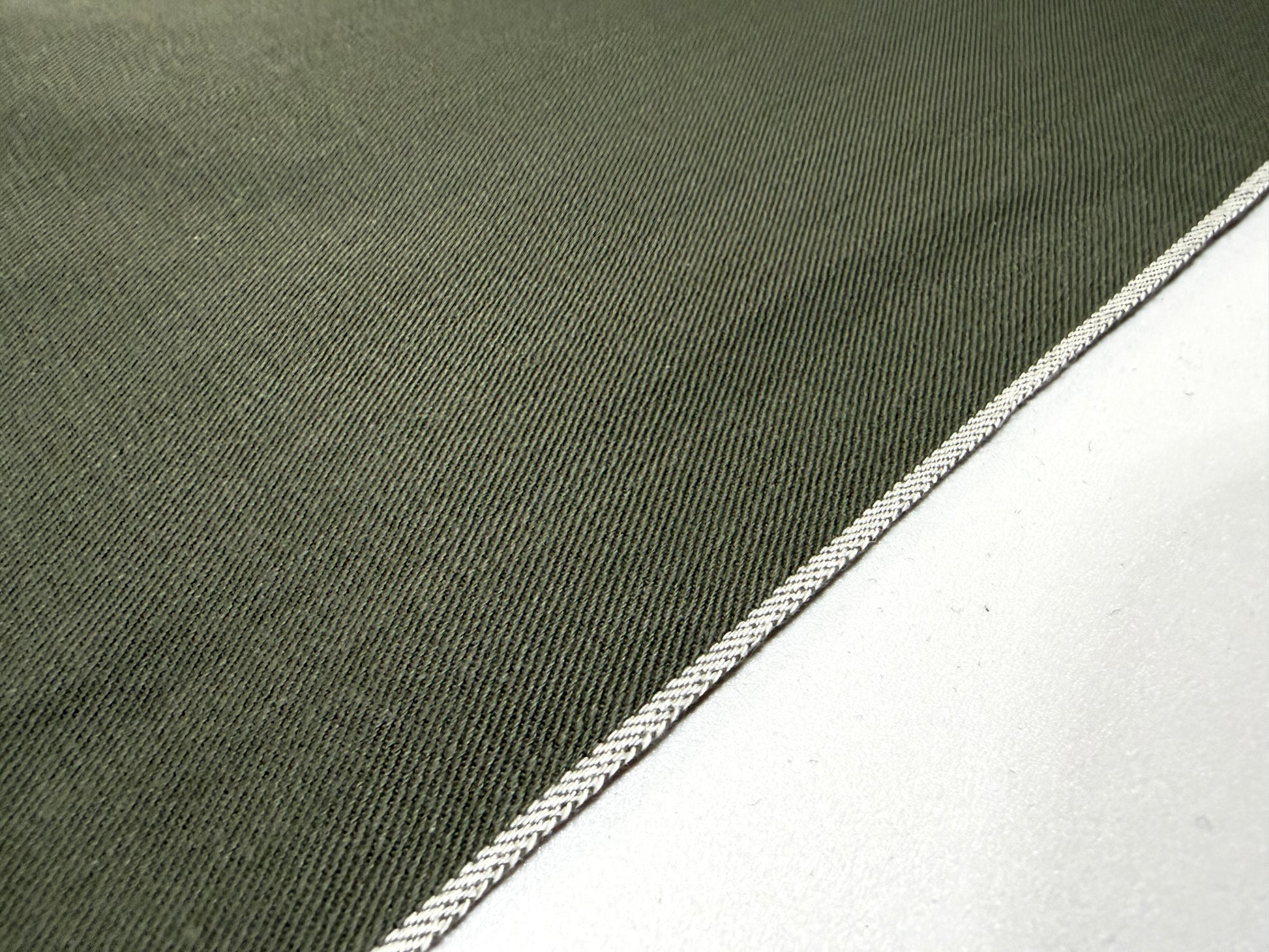 Okayama Denim 7.5 oz Japanese cotton olive dungaree fabric showing traditional selvage edge detail.