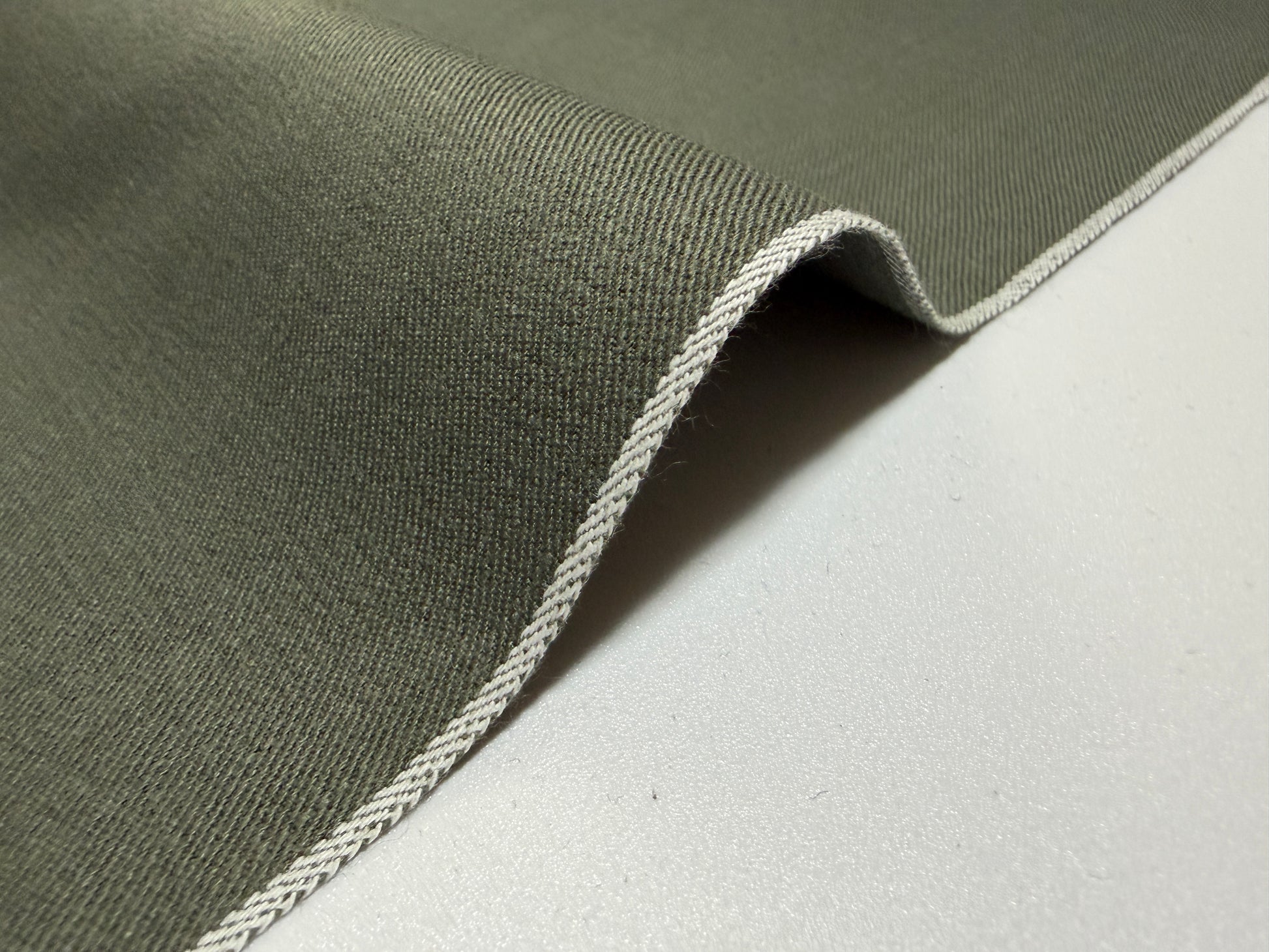 Okayama Denim 7.5 oz Japanese cotton olive dungaree fabric showcasing selvage edge.