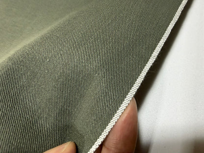 Okayama Fabric close-up showing olive cotton dungaree with traditional selvage edge, highlighting Okayama Denim quality.