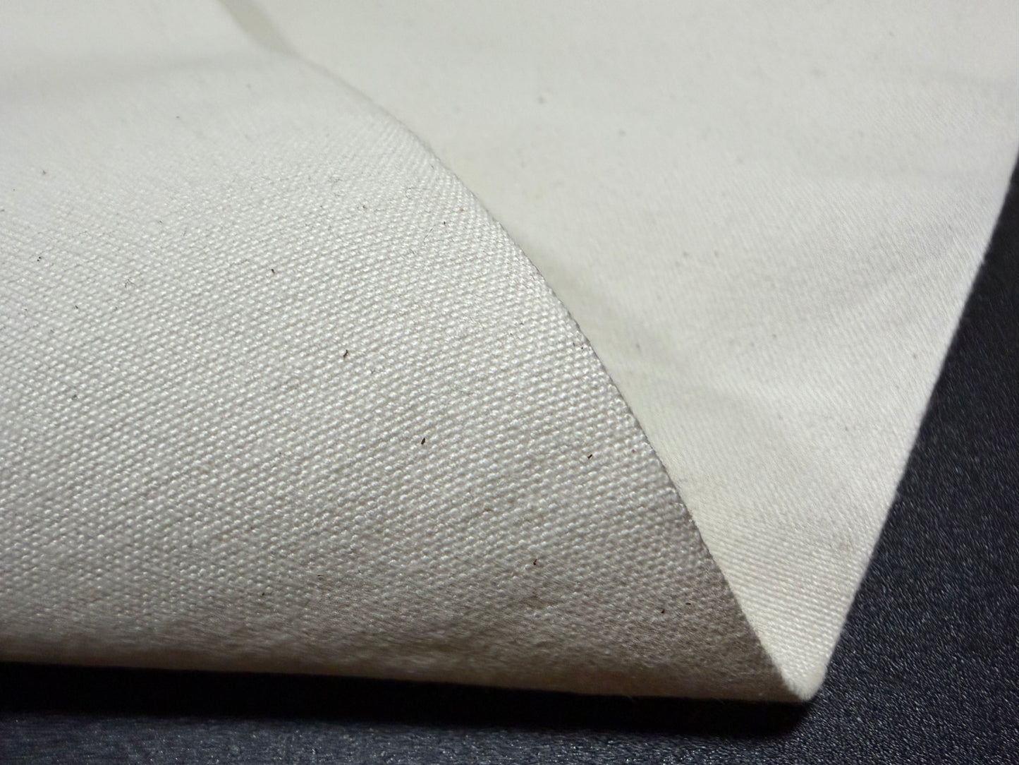 Okayama Denim 10 oz Japanese cotton ecru color canvas fabric by the yard with a textured surface.