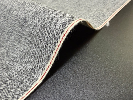 Okayama Fabric | 6 oz Japanese Gray Chambray with Red Selvage detail on black background.