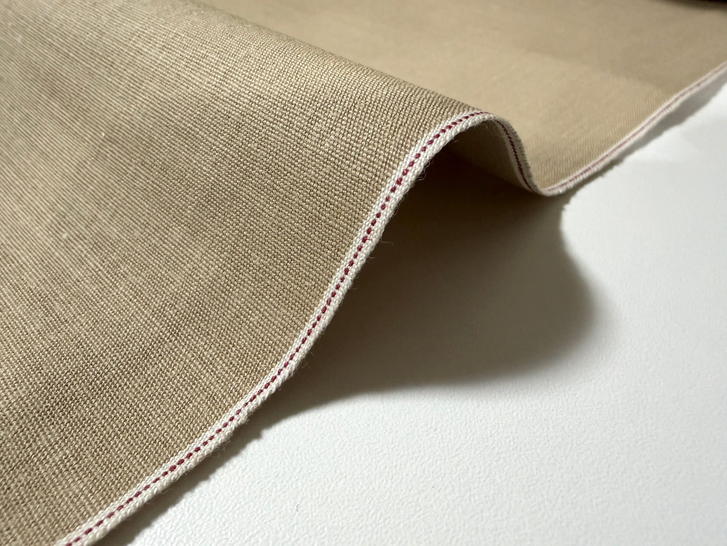 Okayama Denim 8 oz Japanese cotton beige dungaree fabric showing selvage edge detail.