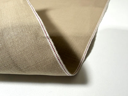 Okayama Denim beige dungaree fabric with traditional selvage edge, showcasing soft texture and quality craftsmanship.