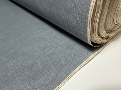 Okayama Denim grayish-blue slub chambray fabric rolled up with red selvage detail.
