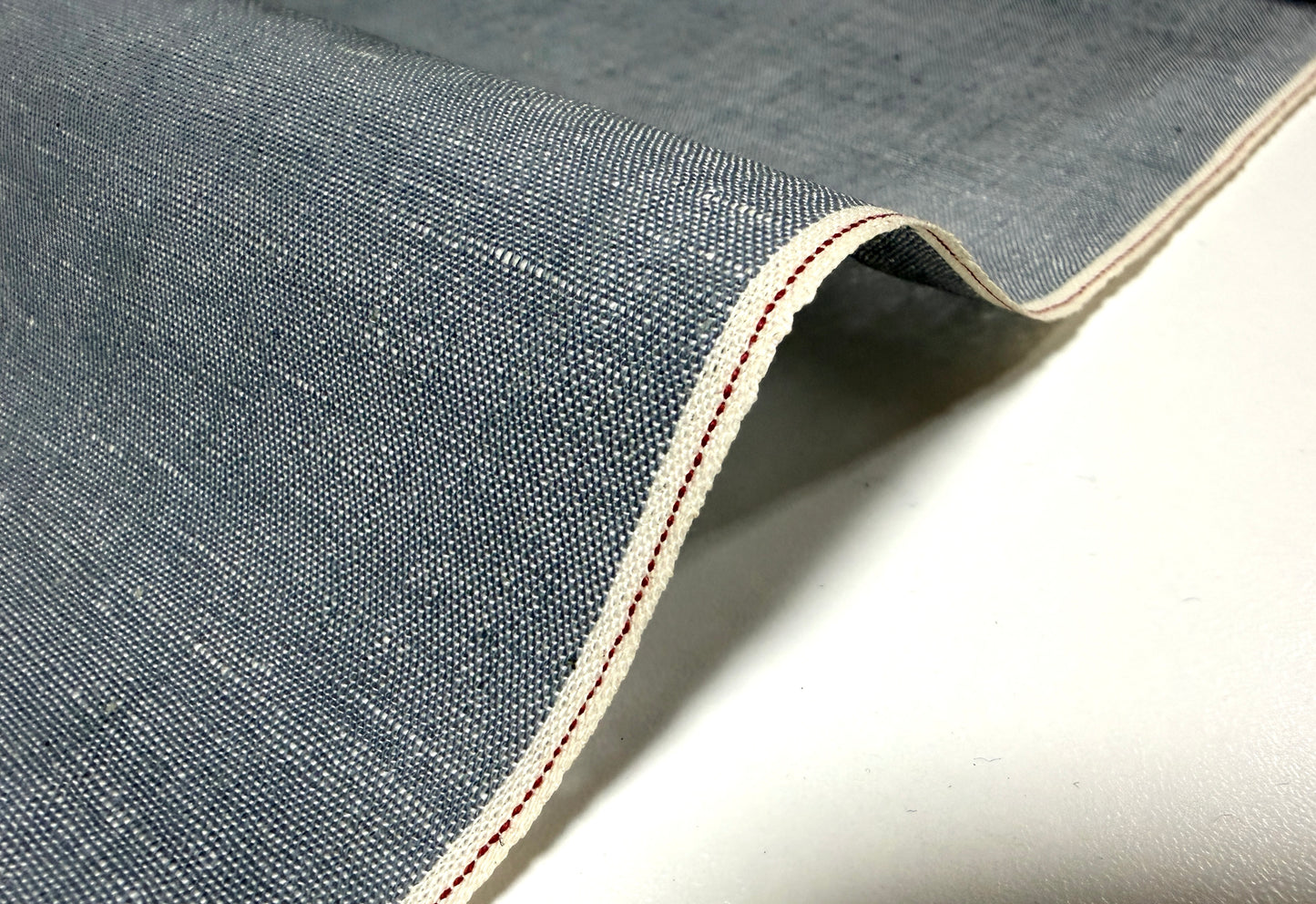 Okayama Denim grayish-blue chambray fabric showcasing red selvage detail.