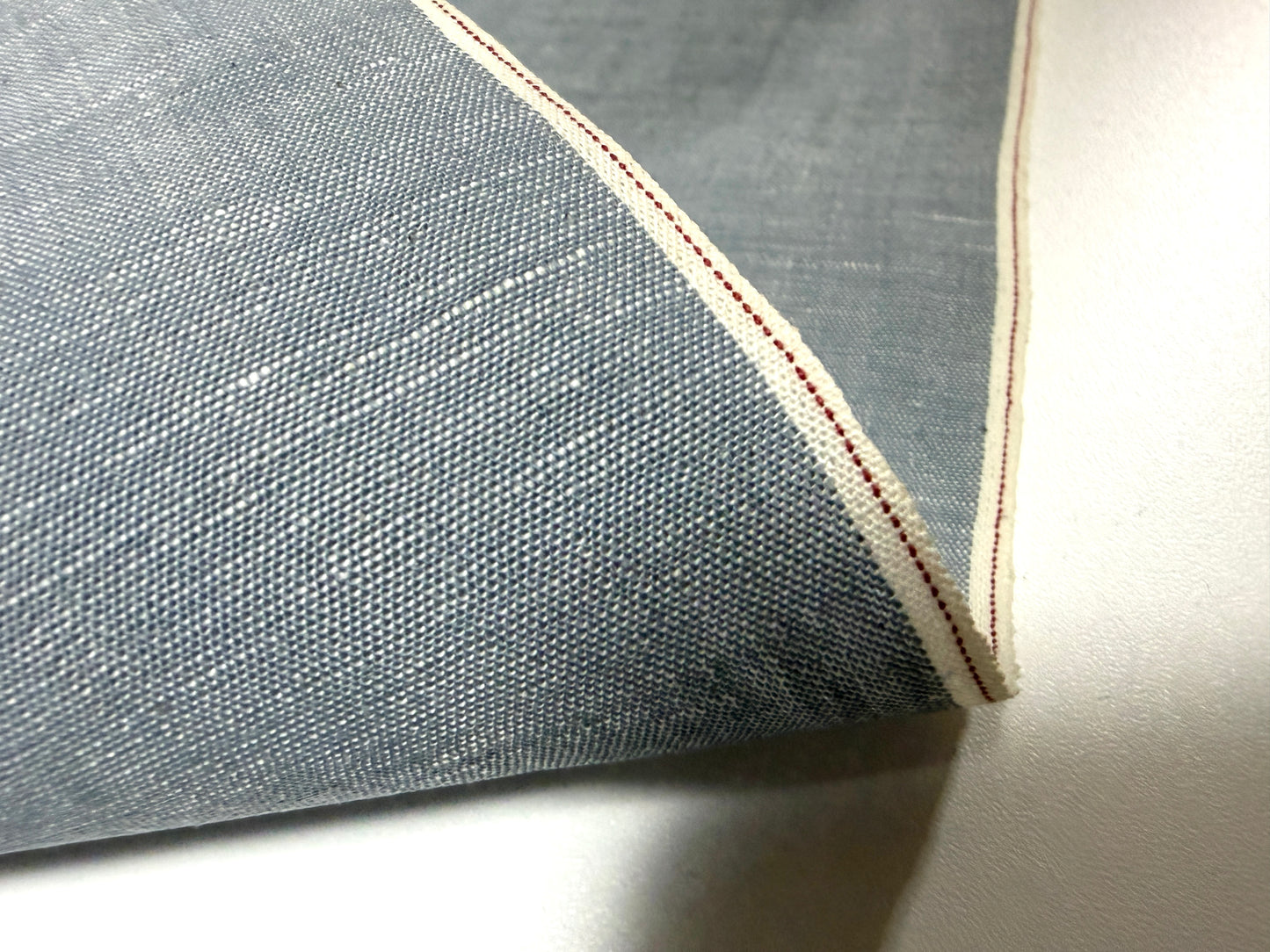 Okayama Denim fabric detail featuring Japanese grayish-blue chambray and red selvage, perfect for stylish apparel.