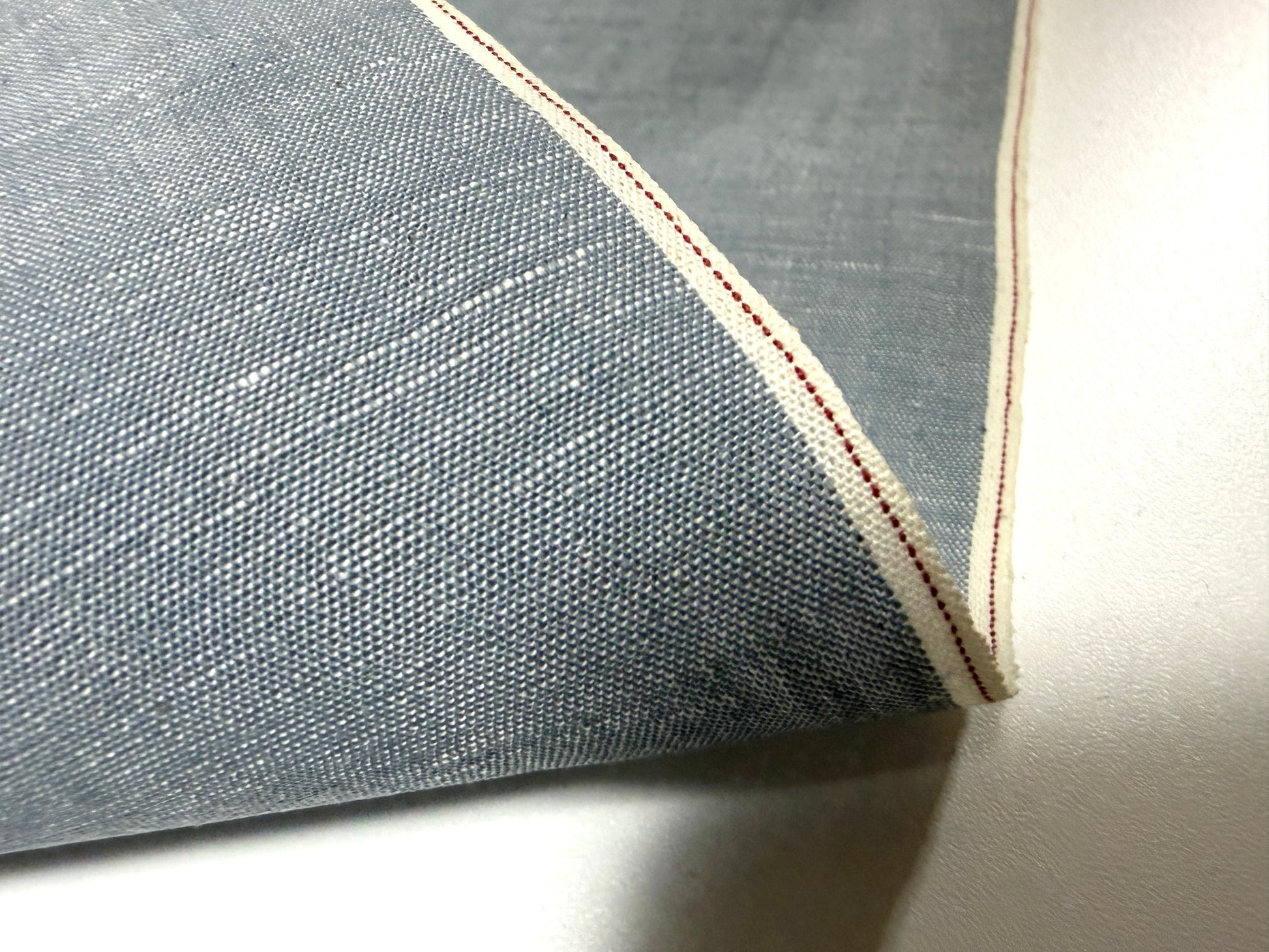 Okayama Denim fabric detail featuring Japanese grayish-blue chambray and red selvage, perfect for stylish apparel.