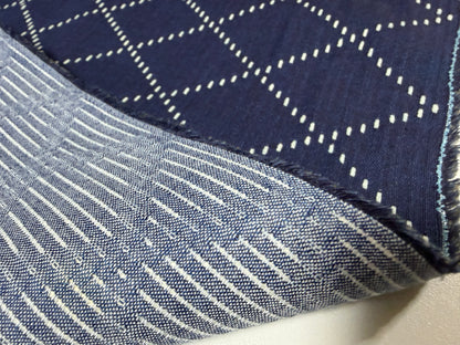 Close-up of Okayama Denim fabric showcasing blue and white Sashiko stitching patterns, ideal for sewing and crafting.