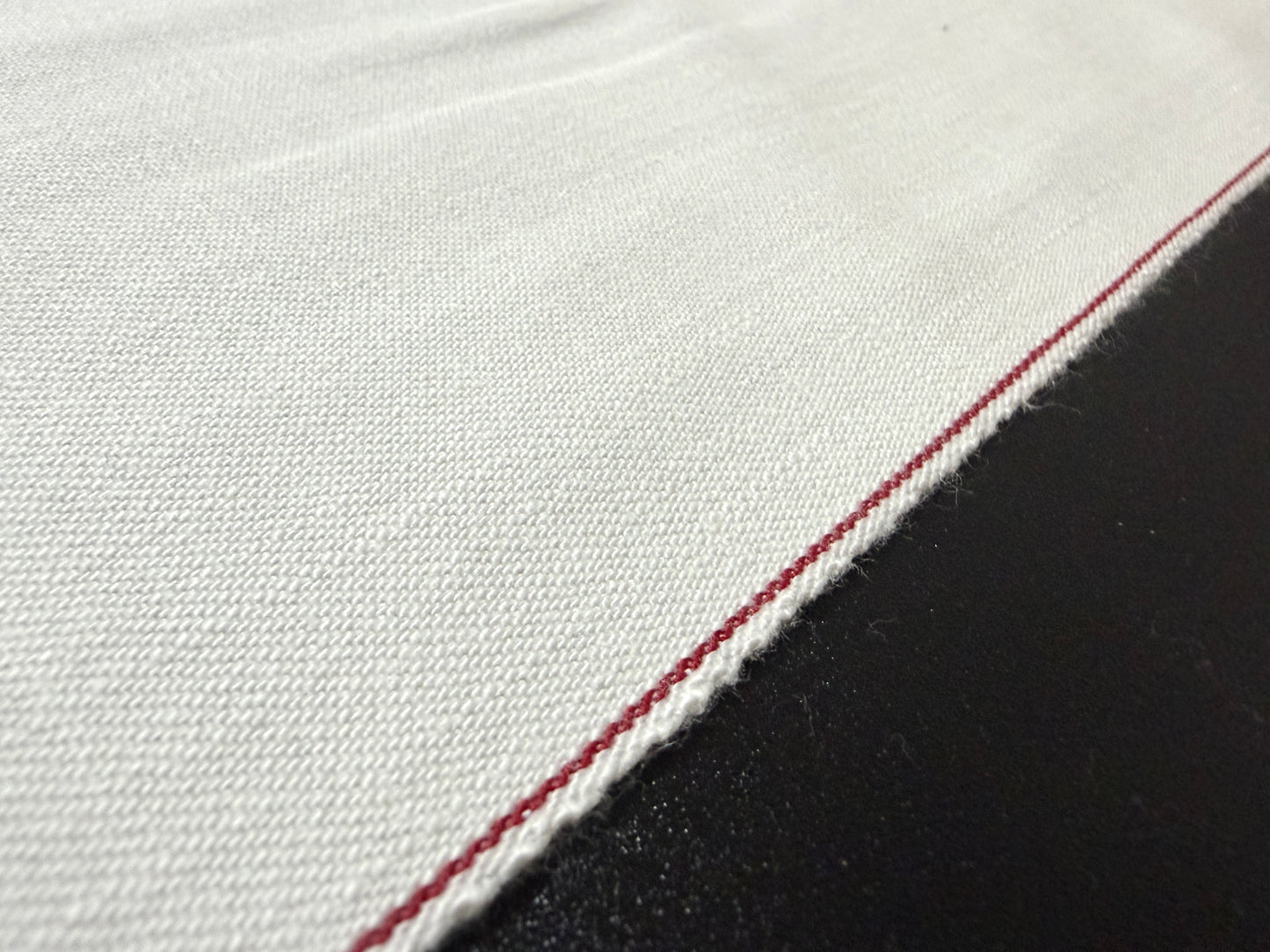 Okayama Denim rare 9.5 oz selvage plane weave cotton fabric close-up with red selvedge detail.
