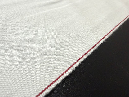 Okayama Denim rare 9.5 oz selvage plane weave cotton fabric close-up with red selvedge detail.