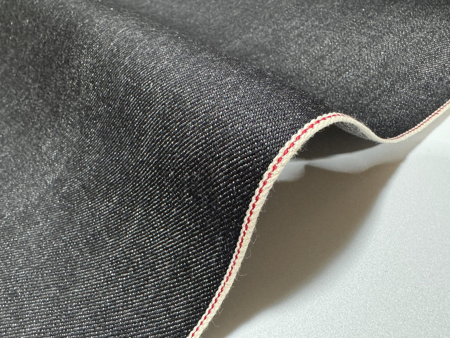 Okayama Denim | 10.5 oz Japanese Cotton Black Selvage Denim showing smooth texture and edge detail.