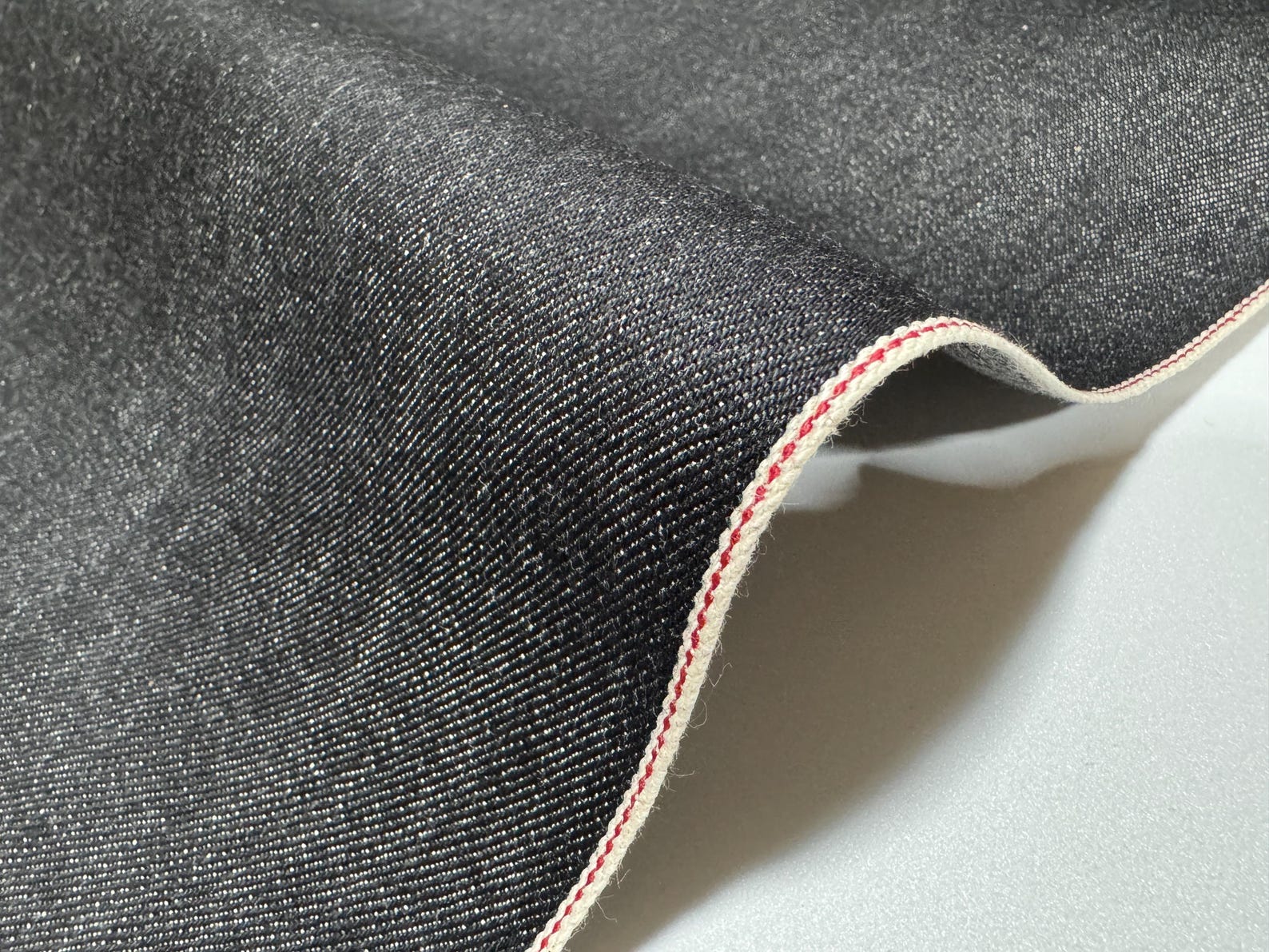 Okayama Denim | 10.5 oz Japanese Cotton Black Selvage Denim showing smooth texture and edge detail.