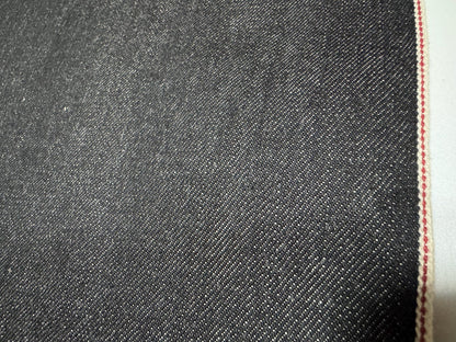 Close-up of Okayama Denim 10.5 oz Black Selvage Japanese Cotton fabric with red selvedge edge.