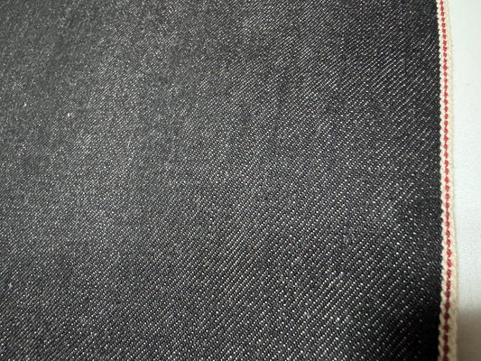 Close-up of Okayama Denim 10.5 oz Black Selvage Japanese Cotton fabric with red selvedge edge.