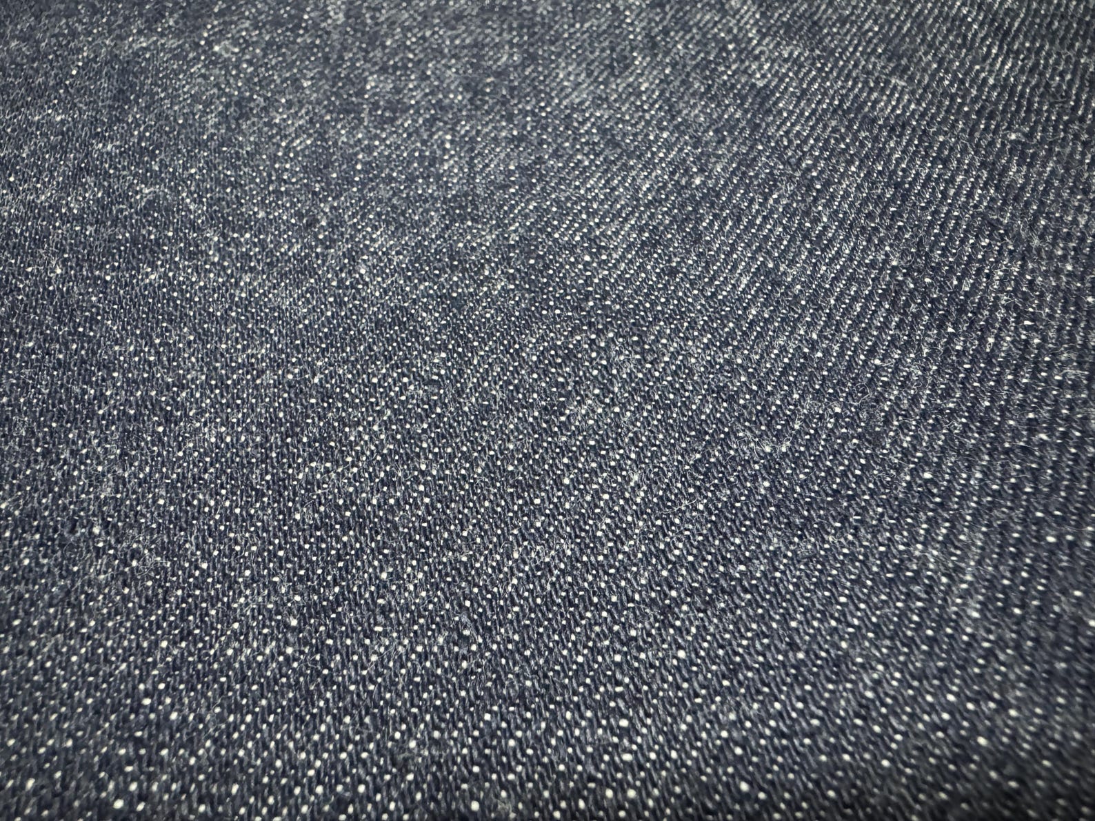 Okayama Denim | 12.5 oz Japanese Indigo Kibata Selvage Denim texture close-up showing intricate weave and quality.