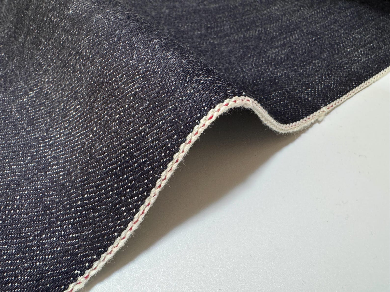 Okayama Denim 19.5 oz Japanese Heavy Ounce Indigo Selvage denim fabric close-up with selvage edge.