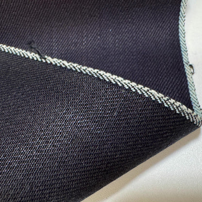 Okayama Denim 12 oz double-sided indigo selvage fabric with white stitching detail on the edge.