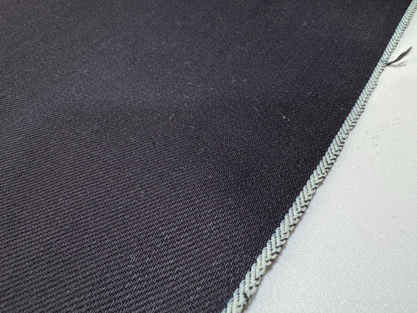 Okayama Denim 12 oz double-sided indigo selvage fabric showcasing deep navy blue color and selvedge edge.