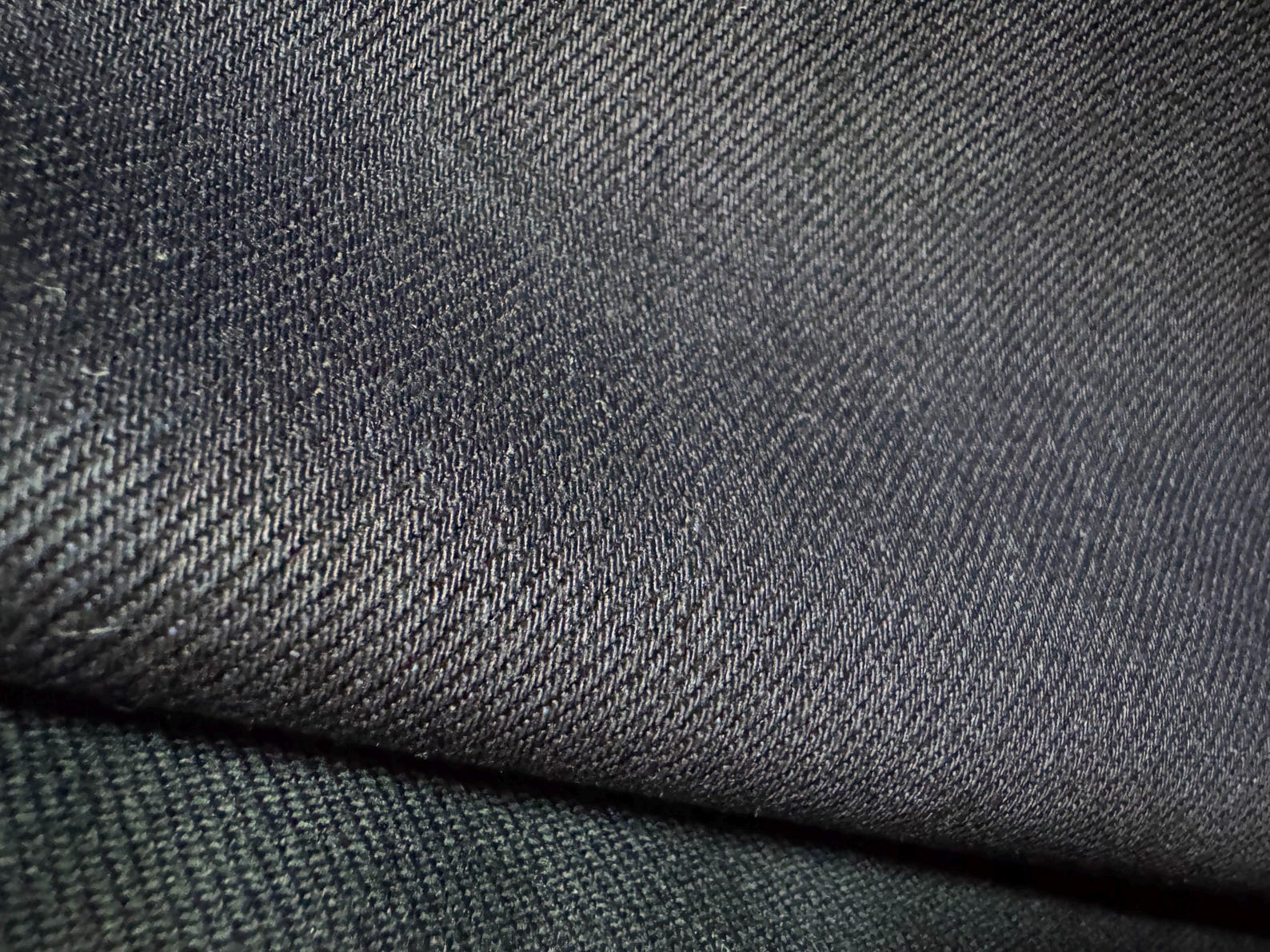 Okayama Denim close-up of 12 oz double-sided indigo selvedge fabric showcasing its smooth texture and deep navy color.