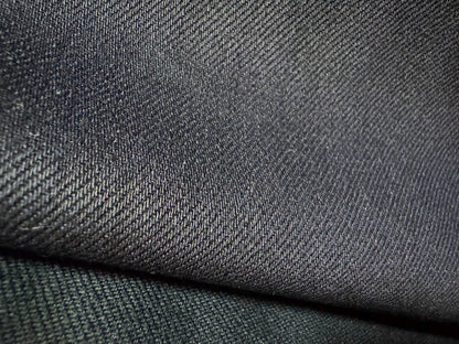 Okayama Denim close-up of 12 oz double-sided indigo selvedge fabric showcasing its smooth texture and deep navy color.