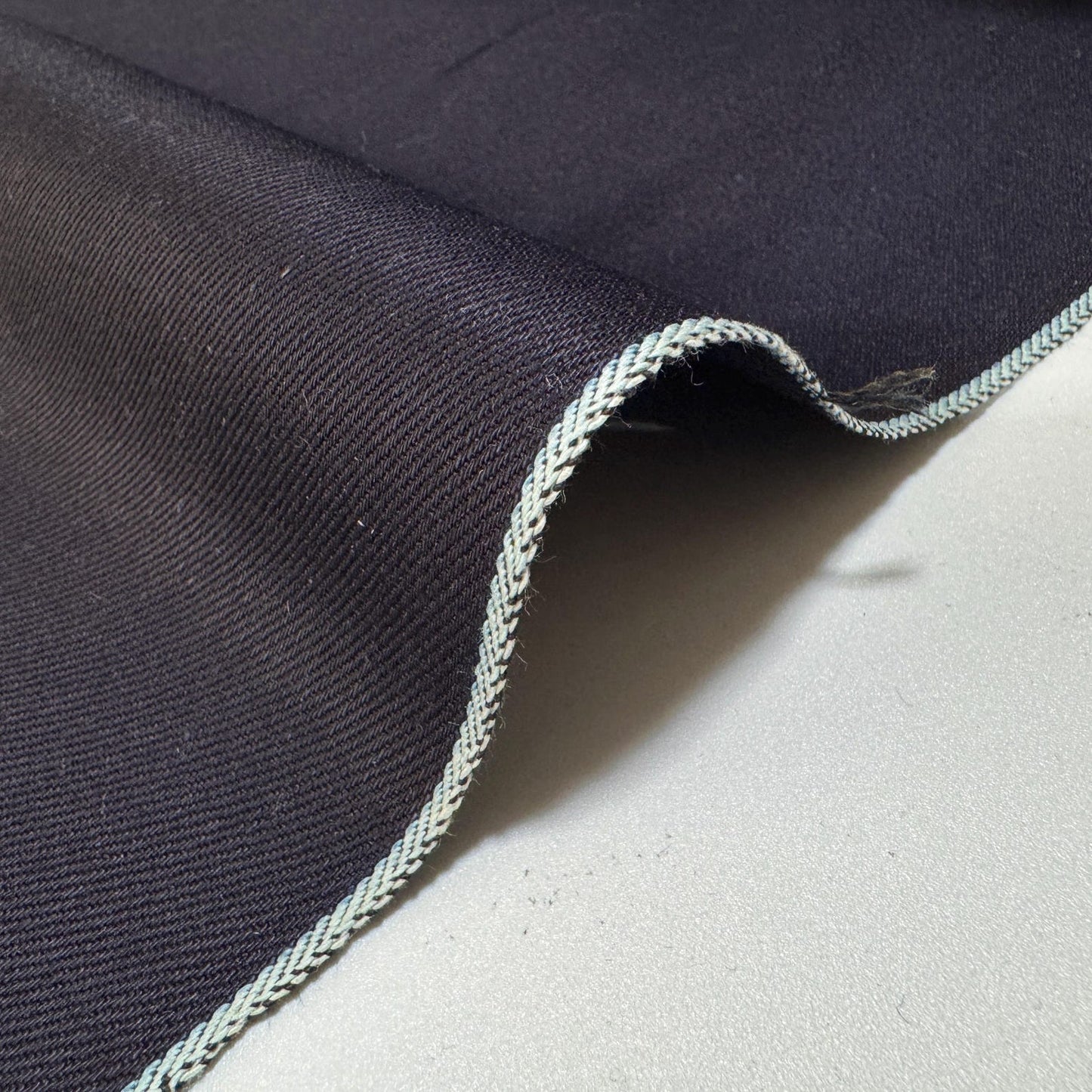 Okayama Denim - 12 oz double-sided indigo selvage showcasing smooth texture and classic selvage edge.