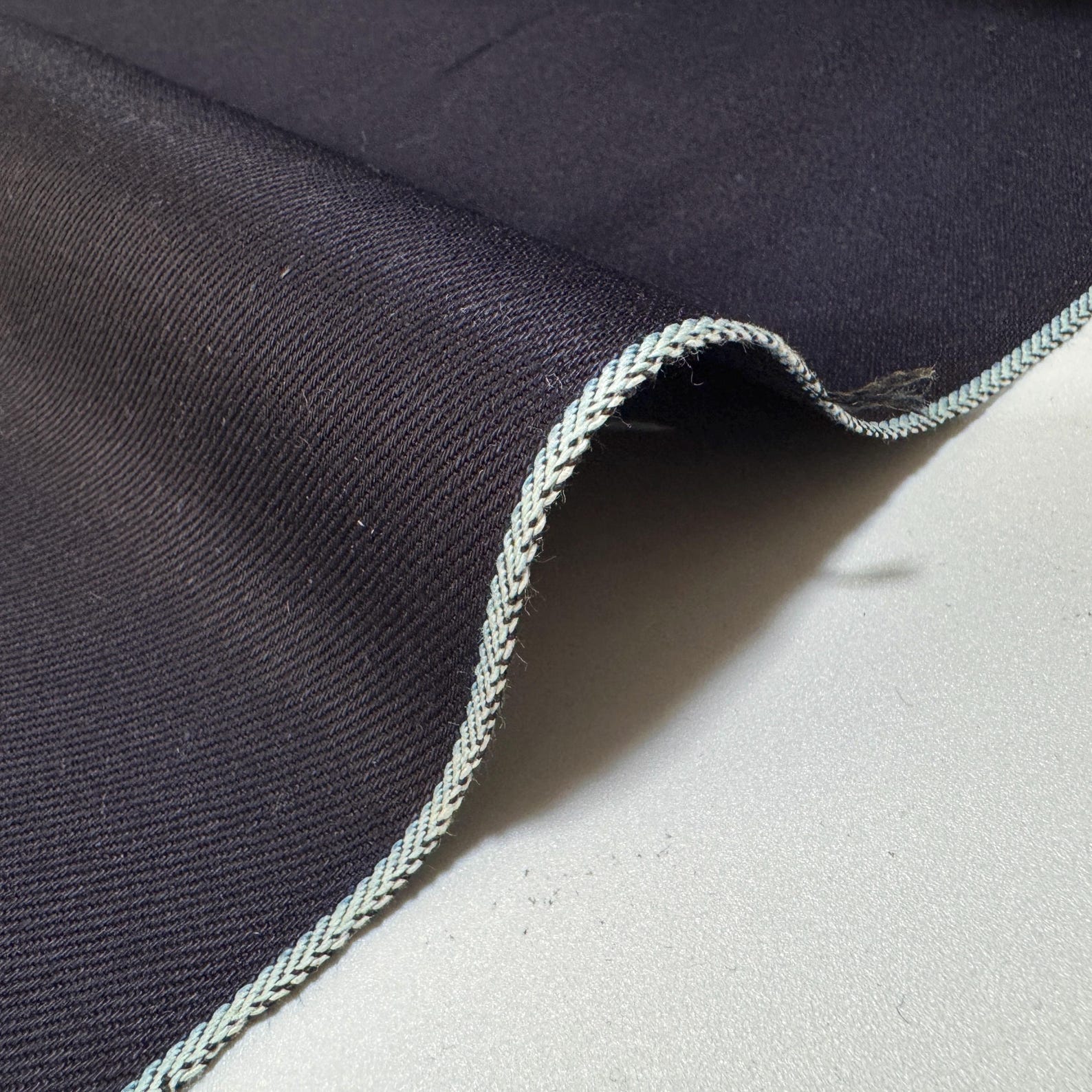 Okayama Denim - 12 oz double-sided indigo selvage showcasing smooth texture and classic selvage edge.