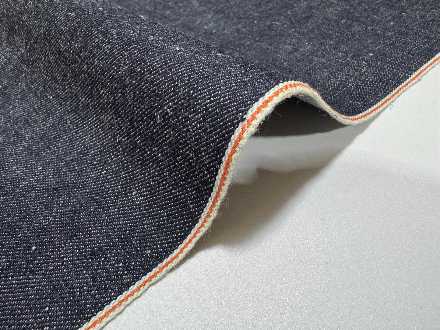 Okayama Denim 13 oz Indigo Kibata Japanese selvage denim fabric showcasing orange selvage edge.