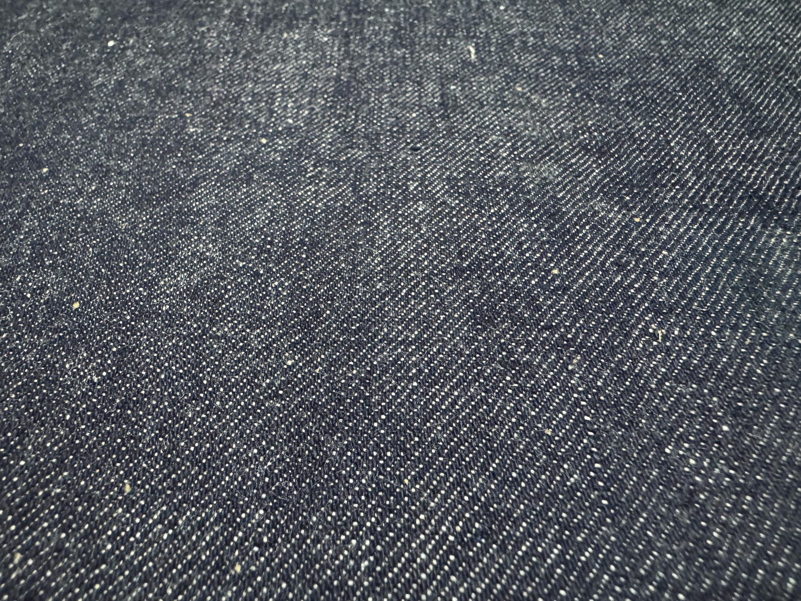Okayama Denim 13 oz indigo kibata Japanese selvage denim fabric close-up showing texture and weave.