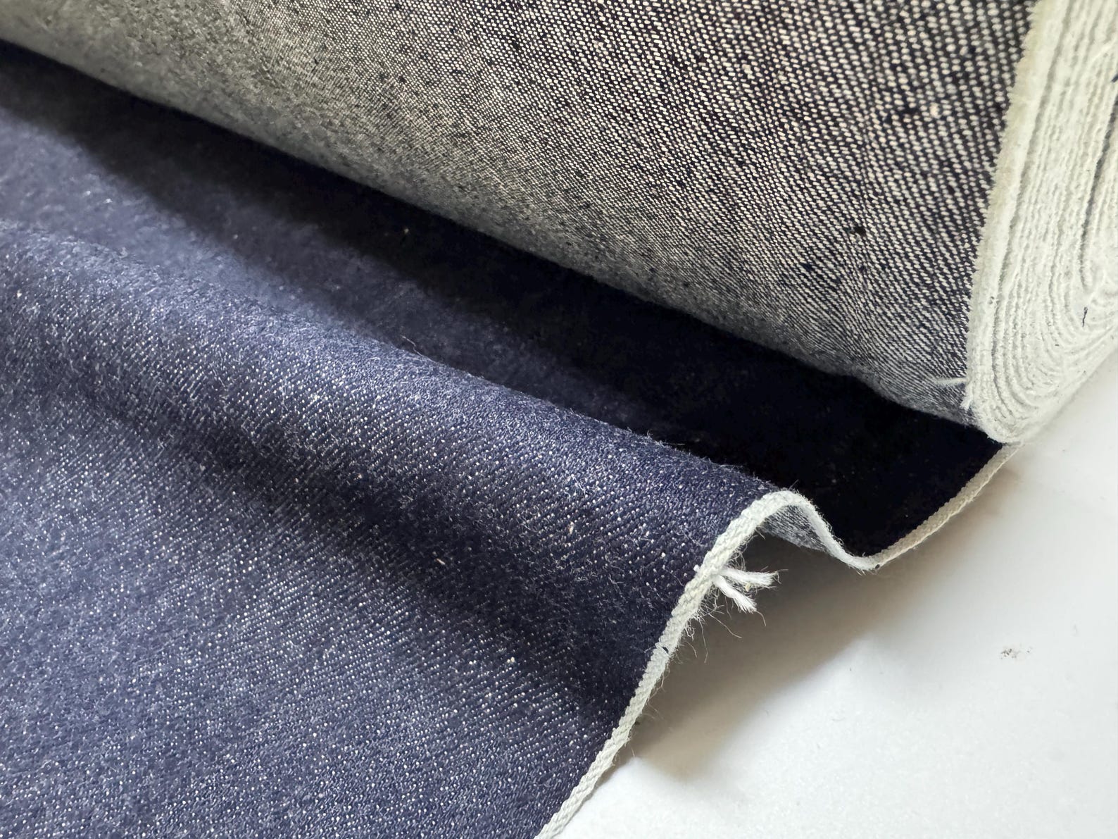 Okayama Denim | 11.5oz indigo rigid selvage Japanese denim fabric showing smooth texture and dark indigo color.