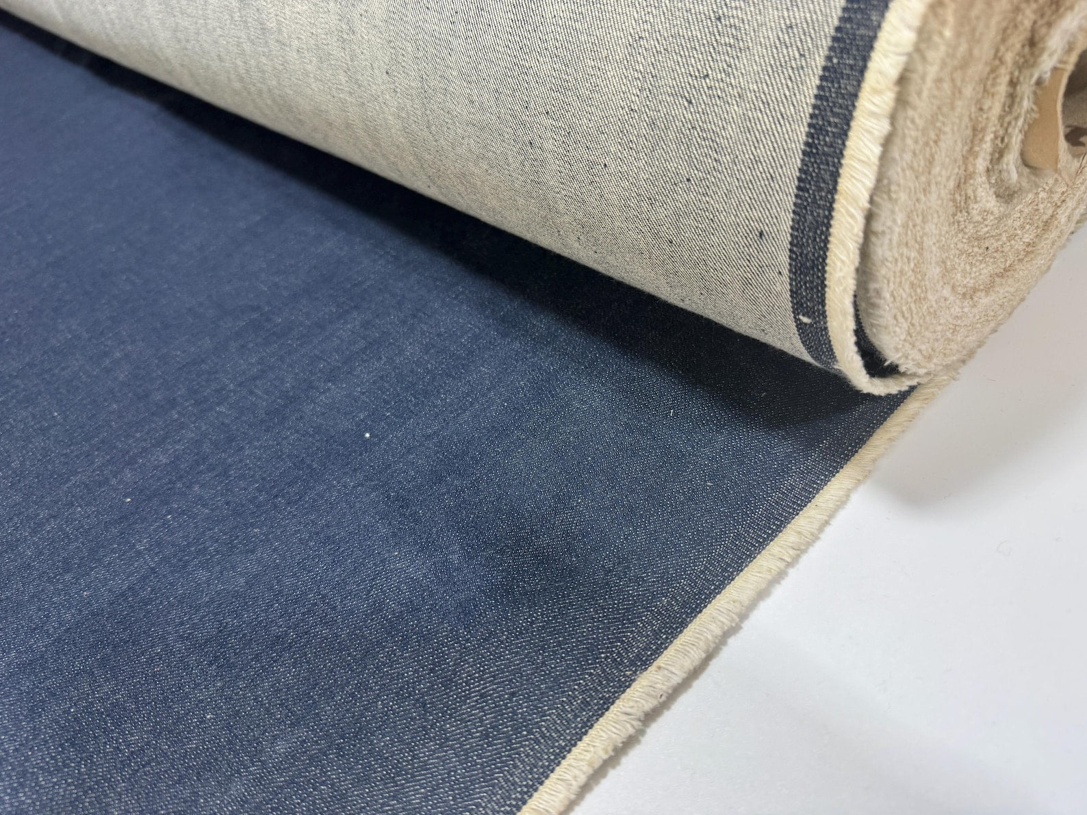 Close-up of Okayama Denim, 12.5 oz double width indigo Japanese denim fabric, showcasing its rich texture and color.