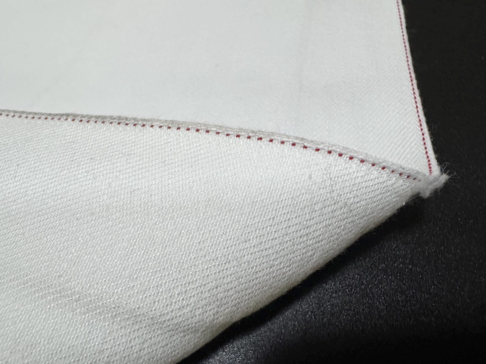 Okayama Denim 13 oz White Selvedge fabric showcasing red selvage edge detail.