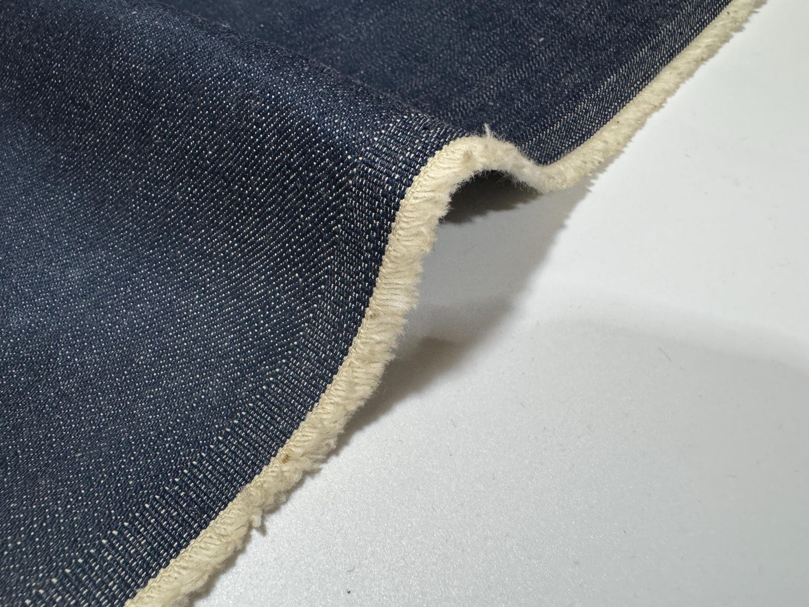 Okayama Denim | 12.5oz Double Width Indigo Japanese denim fabric showing texture and edge detail.