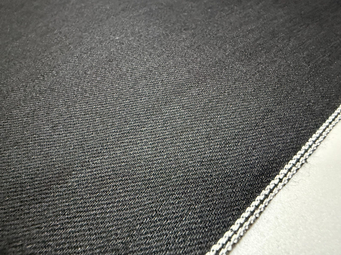 Okayama Denim | 11oz double-sided black Japanese black selvage fabric close-up showing smooth texture and selvedge