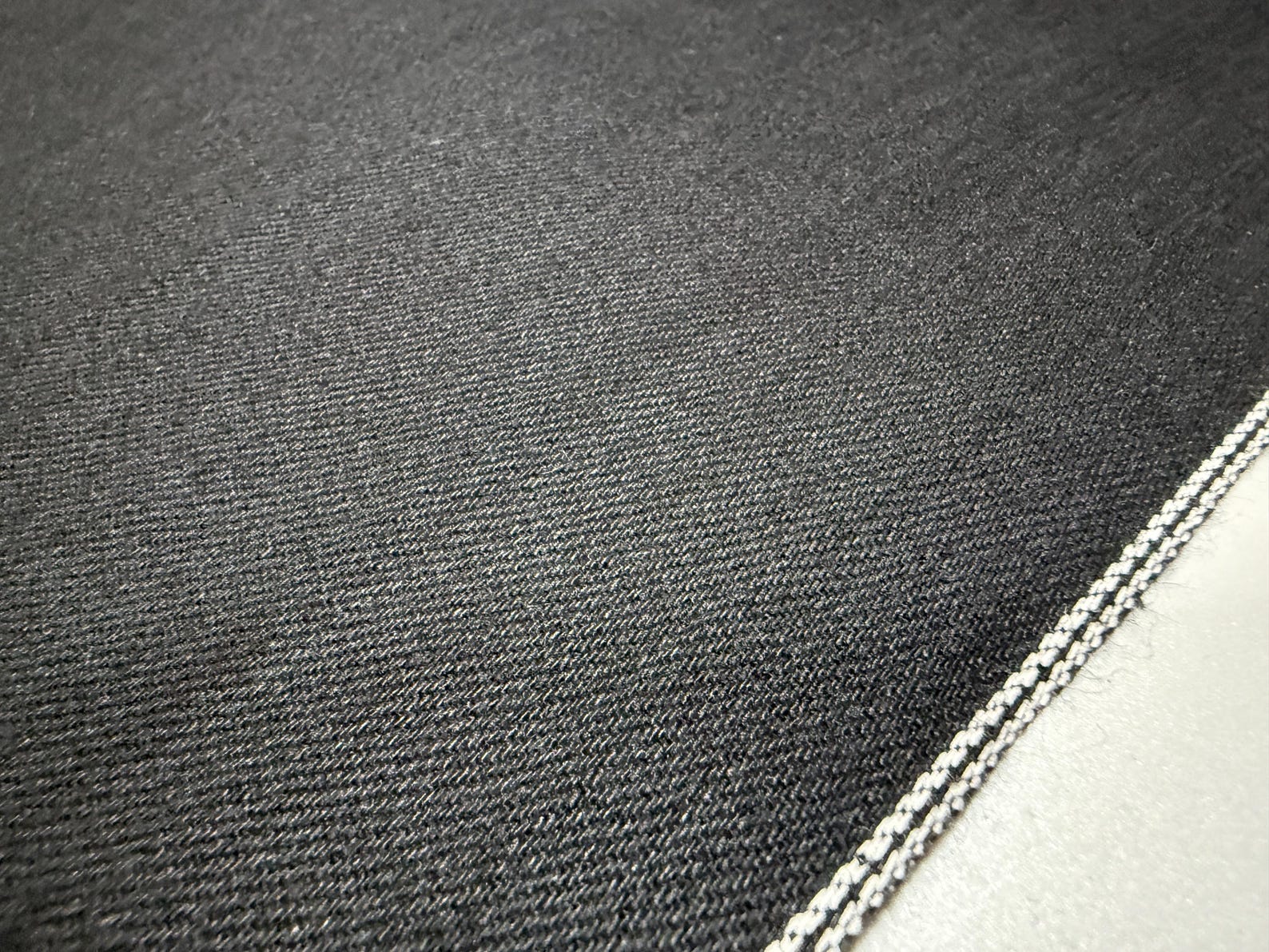 Okayama Denim | 11oz double-sided black Japanese black selvage fabric close-up showing smooth texture and selvedge