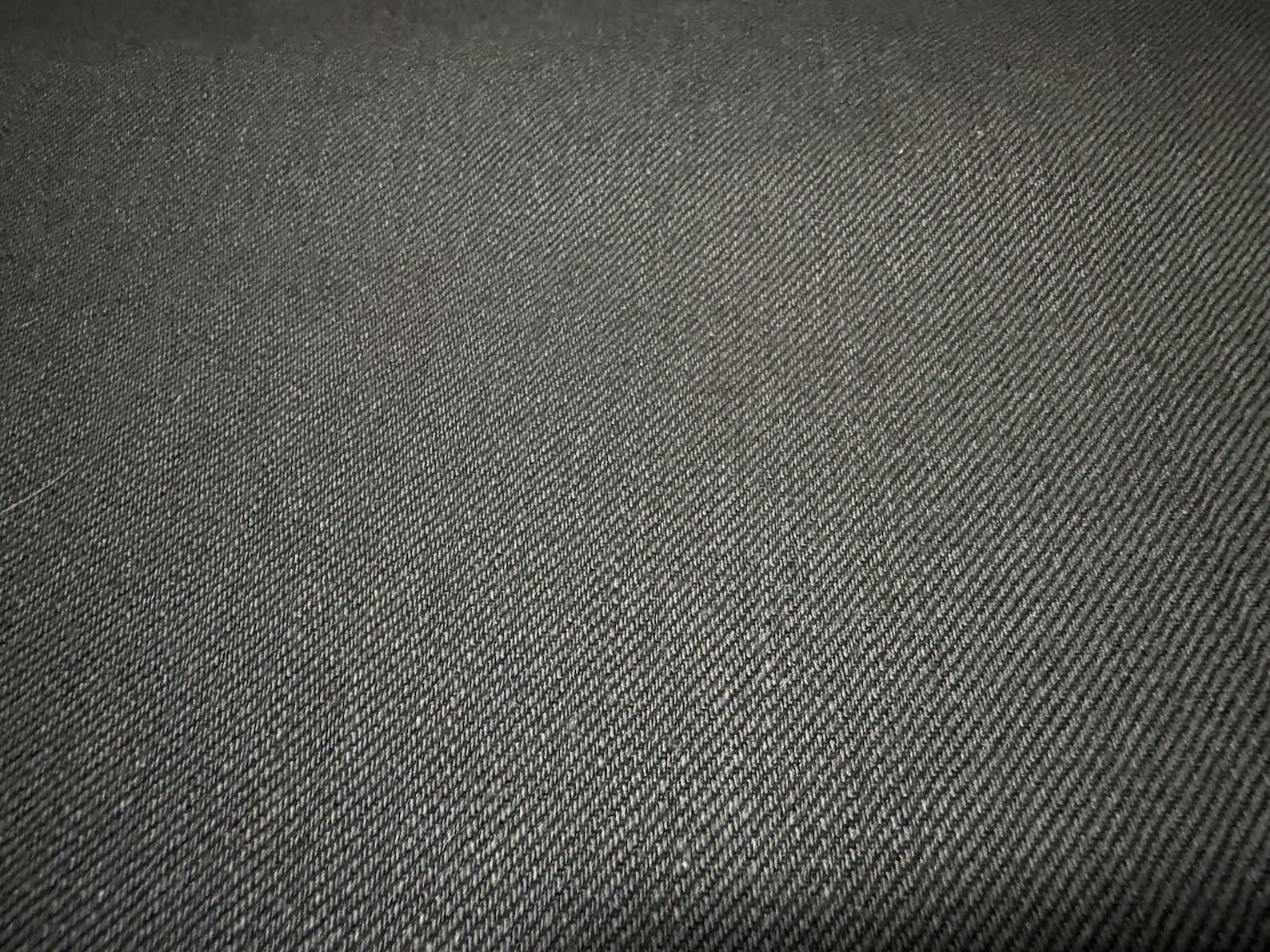 Okayama Denim | Close-up of 11oz double-sided black Japanese selvage fabric texture.