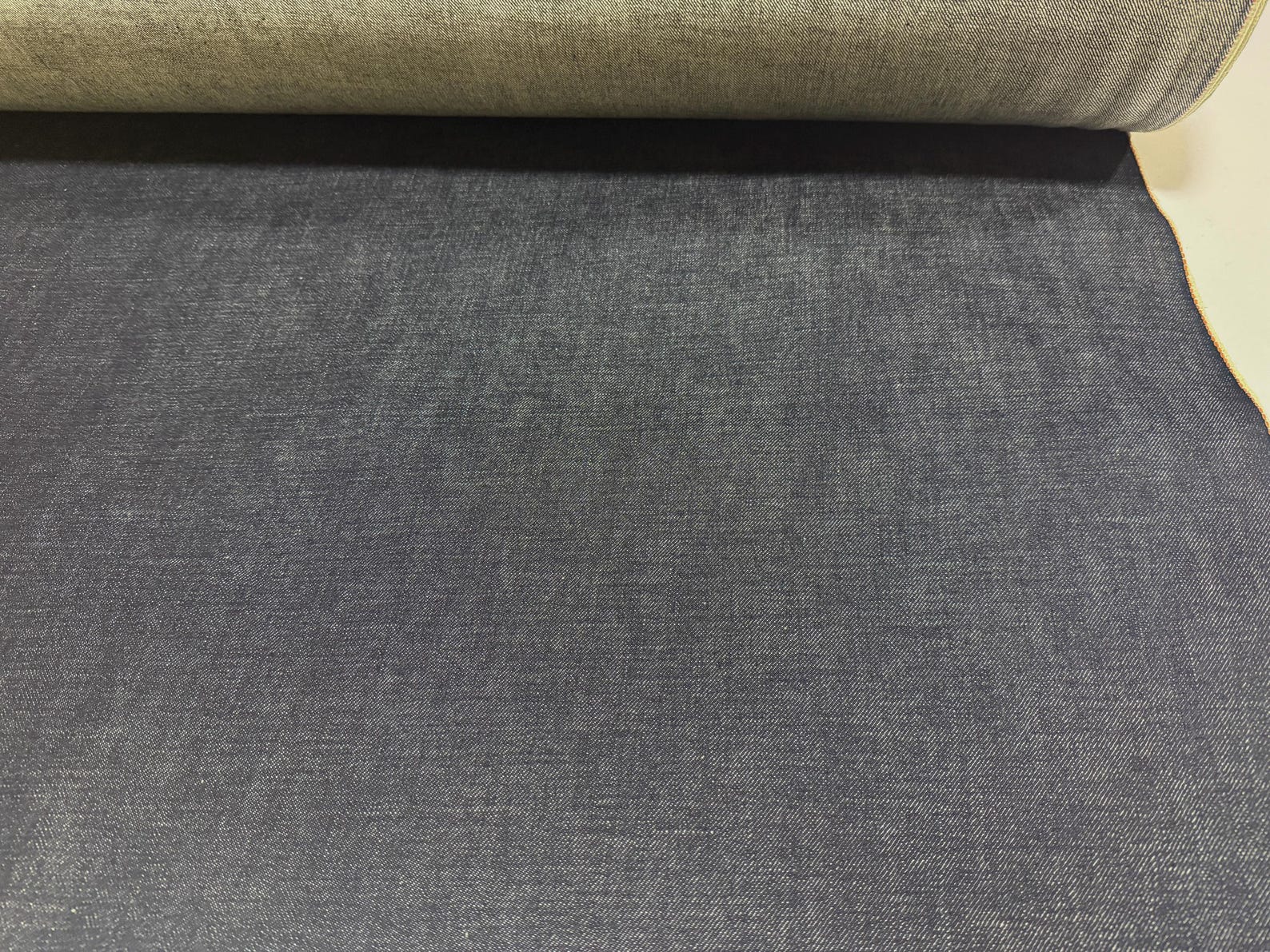 Okayama Denim fabric showing 13.5 oz indigo Japanese selvage denim with a smooth texture for apparel projects.