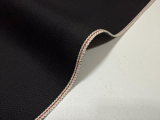 Okayama Denim | 11oz double-sided black Japanese selvage showcasing the smooth texture and unique edge stitching.