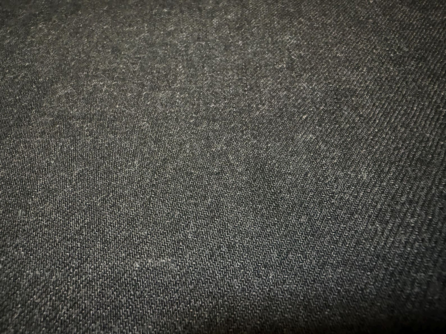 Okayama Denim fabric close-up, showcasing the texture of 13.5 oz black/gray Japanese selvage denim.