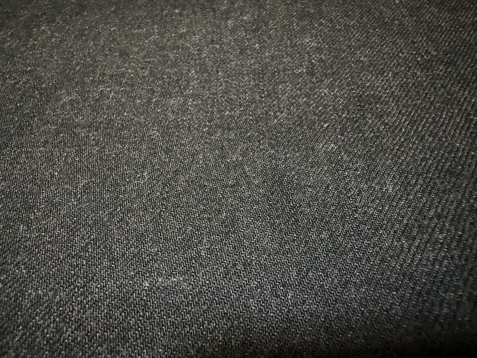 Okayama Denim fabric close-up, showcasing the texture of 13.5 oz black/gray Japanese selvage denim.