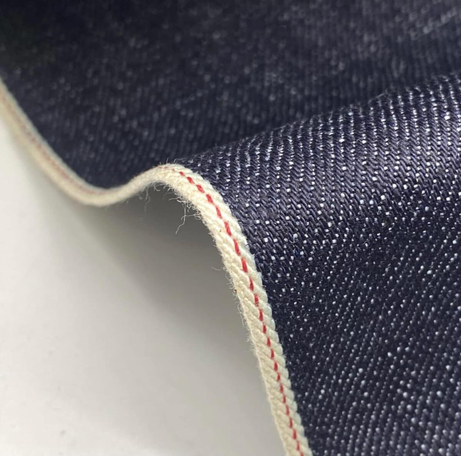 Okayama Denim 15.5 oz indigo selvage Japanese denim fabric with red selvage edge detail.