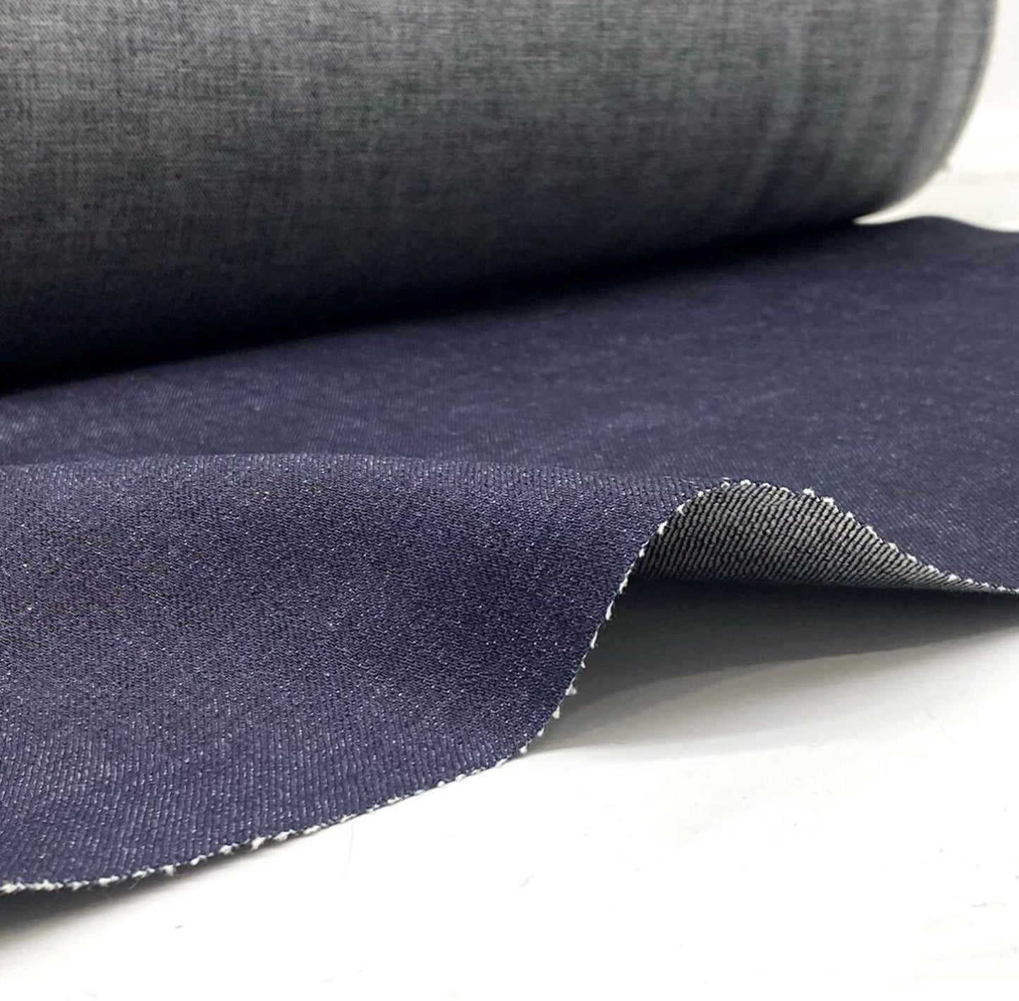 Okayama Denim 15.5oz indigo selvage Japanese blue fabric roll showcasing smooth texture and selvage edges.